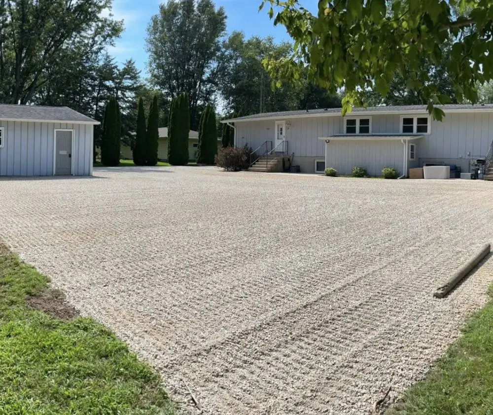 Finished gravel driveway running up to a house and outbuilding